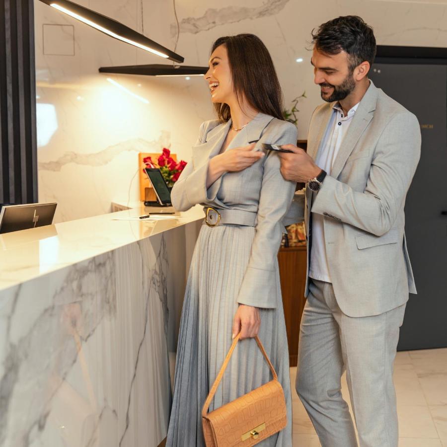 Hotel Pupin Novi Sad Ngoại thất bức ảnh A man helping a woman with her coat
